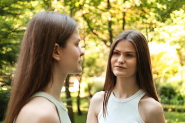 Fototapeta premium Two beautiful twin sisters in park, selective focus