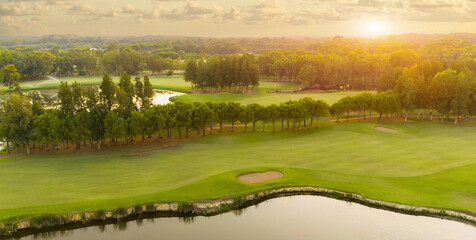 Scenic aerial view of golf course at sunset with stunning sky. Concept of picturesque landscapes and relaxation