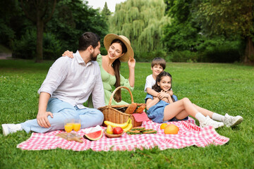 Happy family having picnic together in park