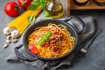 Pasta spaghetti bolognese with minced beef sauce, tomatoes, parmesan cheese and fresh basil in a plate