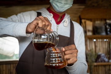 Barista pouring brewed coffee to another pitcher. Conceptual shot of barista while making brewed coffee.