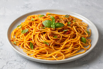 Pasta spaghetti bolognese with minced beef sauce, tomatoes, parmesan cheese and fresh basil in a plate