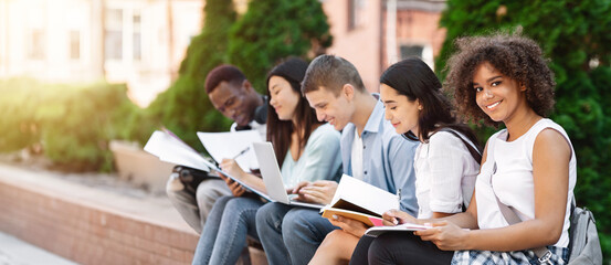 Studying Together. Cheerful African American Student Girl Preparring For Exams Outdoors With Her...
