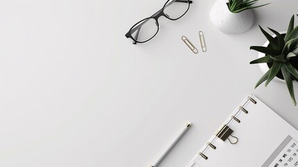 Overhead view of a clean desk setup with a calendar, pen, and glasses
