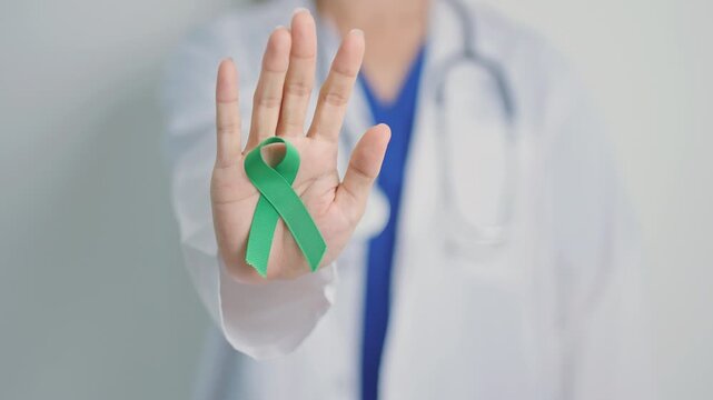 Doctor with green Ribbon for world Mental Health Day, Liver, Gallbladders, bile duct, cervical, kidney Cancer and Lymphoma Awareness month. Healthcare and world cancer day concept
