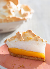 Sunny and Bright Orange Lemon Citrus Meringue Pie on a coral plate with pie in background