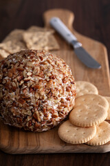 Close-up of a Classic Cheeseball with crackers on a cutting board with cheese knife