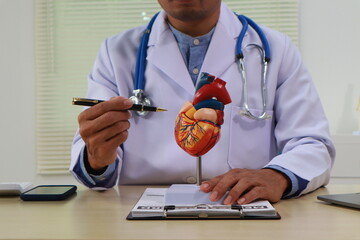 A female nurse works at a desk in an office, focusing on diagnosing and treating cardiovascular...