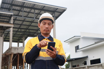 A male engineer at a construction site wears a hardhat and reflective clothing, reviewing blueprints. He coordinates with a team, safety and efficient project development in construction industry.