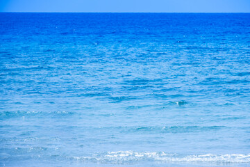 Nature of the beach and sea Summer with sunshine, sandy beaches, clear blue waters sparkling against the blue sky. On an island with good ecology and environment Background for summer vacation concept