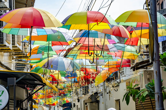 Decorative, colourful, umbrellas hanging overhead along Lorong Song Long off Armenia Street in George Town, Penang, Malaysia and provide shade