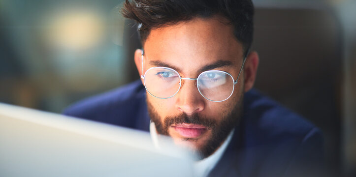Thinking, night and man with glasses, laptop and test of software for cybersecurity, programmer and office. Serious, vision and employee for coding of website, IT and information technology in dark