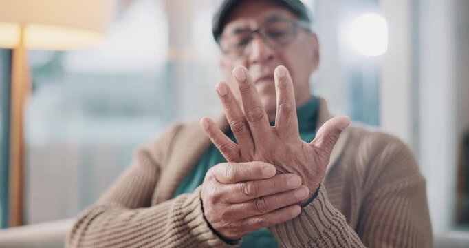 Elderly man, hands and sofa with arthritis, ache or joint pain from fibromyalgia or inflammation at home. Closeup of senior male person with sore fingers, palm or carpal tunnel syndrome at house