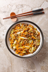 One Pot Egg Roll Bowl with beef, onion, carrot, cabbage closeup on the table. Vertical top view from above