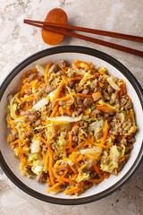 Egg roll bowl with vegetables and meat traditional asian food in one pot close-up on table. Vertical top view from above