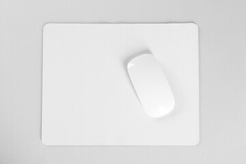 Wireless mouse and mousepad on white background, top view