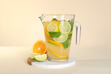 Freshly made lemonade with mint in jug on beige background