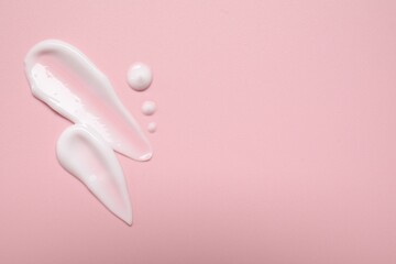 Face cream on pink background, top view. Space for text