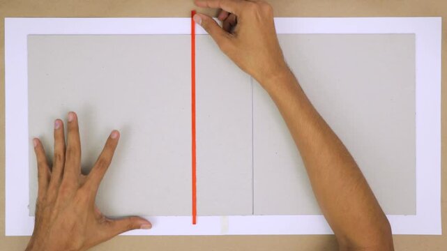 Three pieces of cardboard held together by binding rulers on a flat surface