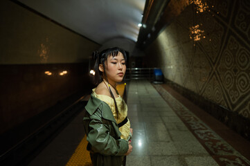 Portrait of an Asian young woman at the subway station. Moving train.