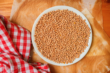 Plate of chickpeas with burned baking paper and red checkered cloth.
