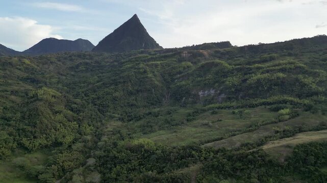 Aerial climbs up slope to Cerro Tusa pyramid peak, Venecia Colombia