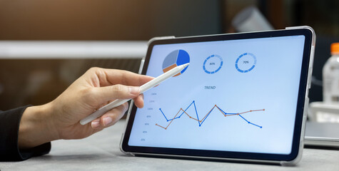 close up manager of marketing department use stylus pen to write or check summary profit report and performance of company on tablet in meeting office room for finance and roi of business concept