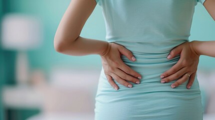 Close up of a pregnant woman performing back pain relief exercises at home with a serene blurred background