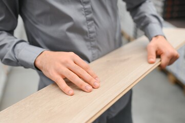 A young man chooses laminate flooring in the hardware store