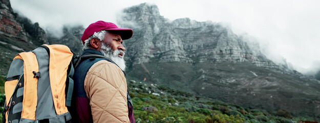 Senior, mountain or black man hiking in forest adventure or journey in wood for outdoor travel. Banner, nature and person thinking on trail walking for holiday, break or trekking to explore in France © David/peopleimages.com