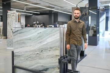 Fototapeta premium Man choosing tile among different samples in store