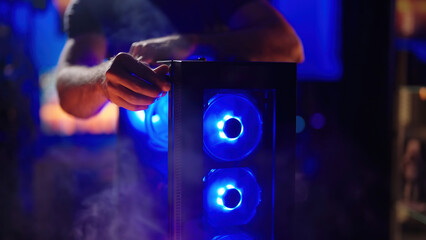 Person assembling smoking hot gaming RGB computer glass panel