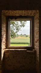 Fototapeta premium window in a old abandoned house with rural background