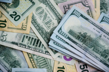 Big amount of US dollar bills in different nominations on table. Many dollar banknotes under...