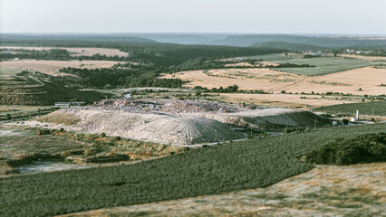 Aerial Dump trucks unloading garbage over waste landfill. Environmental pollution. Outdated method of waste disposal
