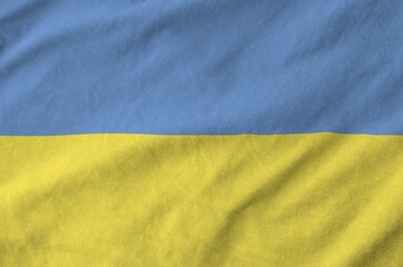 Ukraine flag depicted on folded wavy fabric of old cloth close up