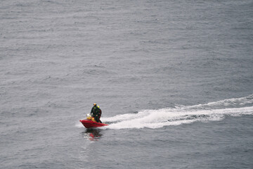 Emergency lifeguard patrolling sea on a scooter