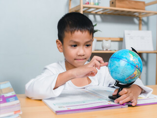 Asian boy looking and point your finger at globe find the location of countries in the world, Concept for research global warming, global network, SEO search engine, Save the Earth, Kid Education.