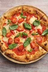 Delicious Margherita pizza on wooden table, top view