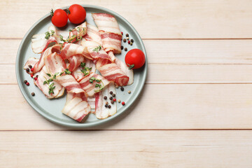 Slices of raw bacon, spices and tomatoes on wooden table, top view. Space for text