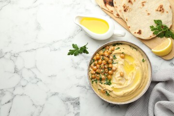 Delicious hummus with olive oil, chickpeas and pita on white marble table, flat lay. Space for text