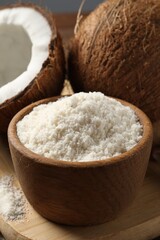 Coconut flour in bowl and fresh fruits on table, closeup