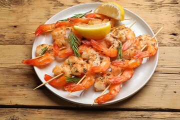 Skewers with delicious grilled shrimps served on wooden table