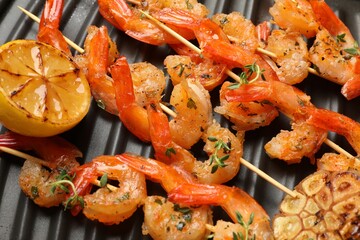 Skewers with delicious shrimps on grill pan, top view