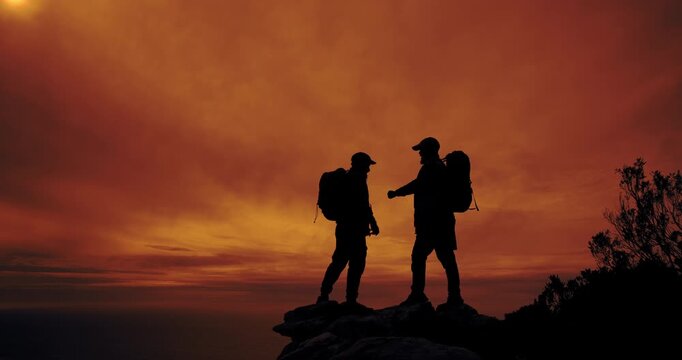 People, silhouette and high five for hiking, achievement and success outdoor on mountain with backpack. Hiker, sunset and teamwork or celebration in nature for fitness goals, exercise and performance