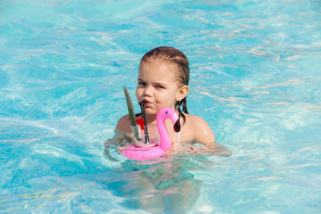 A little girl splashes happily in the pool on a sunny day. Bright colors capture the essence of summer fun and carefree moments. Ideal for family and children's materials.