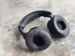 Object, gadget and audio accessory. A heavily used headphone placed on a floor.