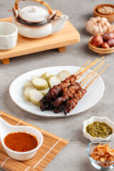 Pork Satay or Sate Babi. Pork Satay served with a Peanut sauce and slices of lontong or ketupat (rice cakes)