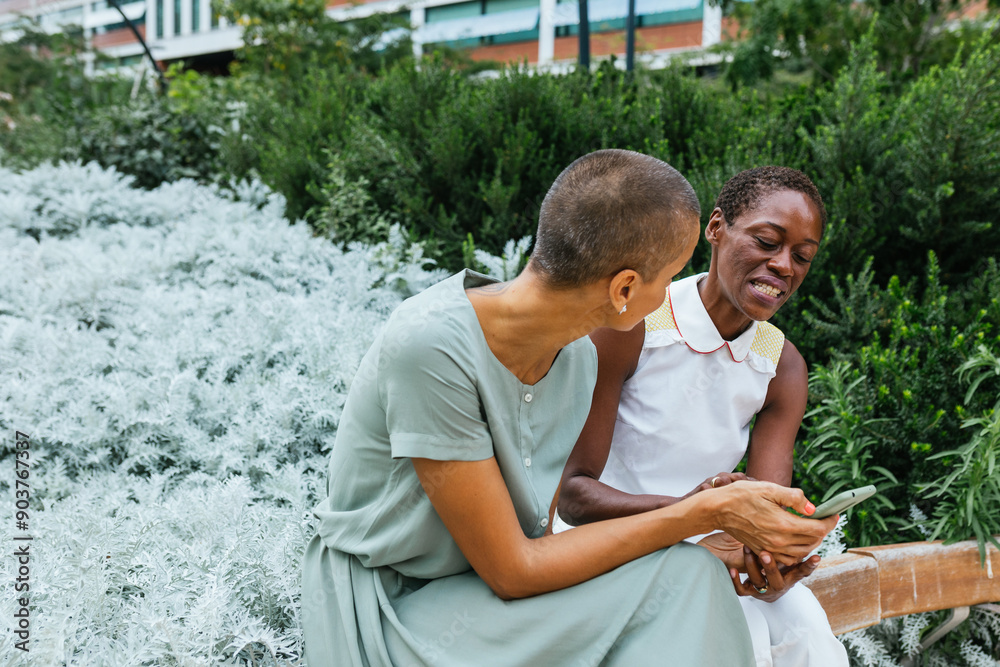 Wall mural Businesswomen sharing a laugh outdoors