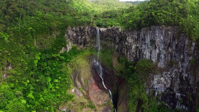 Picturesque flying over the mountain creek fall down from steep high cliff to wide green jungle valley. Cascade 500 Pieds waterfall also known as Cascade des Galets on Mauricius island in Indian ocean